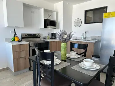 a kitchen with a black table and chairs in a kitchen at Modern Apartment in Downtown. A/C+ Wifi! in San Salvador