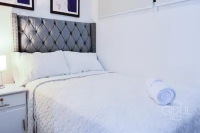 a bedroom with a white bed with a metal headboard at Modern Apartment in Downtown. A/C+ Wifi! in San Salvador