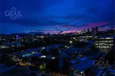 a view of a city at night at The Downtown Apartment - 3 A/C bedroom + WiFi in San Salvador
