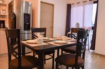 a dining room with a table and chairs and a refrigerator at The Downtown Apartment - 3 A/C bedroom + WiFi in San Salvador