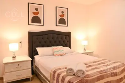 a bedroom with a bed with two night stands and two lamps at The Downtown Apartment - 3 A/C bedroom + WiFi in San Salvador