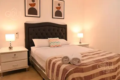 a bedroom with a bed with two night stands and two lamps at The Downtown Apartment - 3 A/C bedroom + WiFi in San Salvador