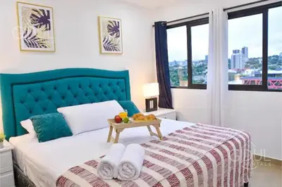 a bedroom with a bed with a tray of fruit on it at The Downtown Apartment - 3 A/C bedroom + WiFi in San Salvador
