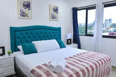 a bedroom with a large bed with towels on it at The Downtown Apartment - 3 A/C bedroom + WiFi in San Salvador