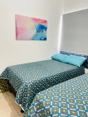 a bedroom with two beds and a painting on the wall at Tiny house Santa Ana in Santa Ana