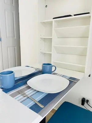 two white plates and two blue cups on a kitchen counter at Tiny house Santa Ana in Santa Ana