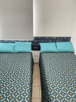 two beds sitting next to each other in a room at Tiny house Santa Ana in Santa Ana