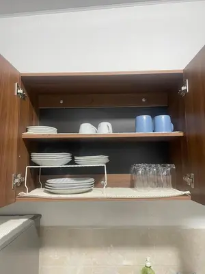 a kitchen cabinet with plates and dishes on shelves at Tiny house Santa Ana in Santa Ana