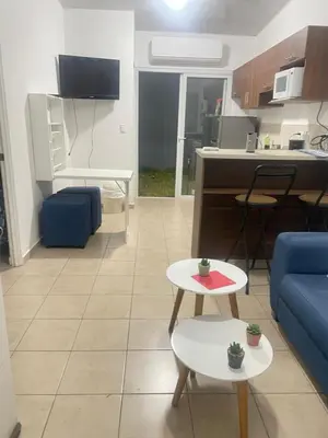 a living room with a blue couch and a kitchen at Tiny house Santa Ana in Santa Ana