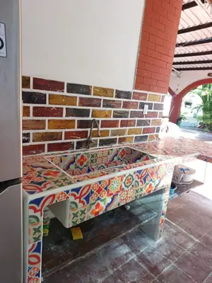 a bench with mosaics on it next to a brick wall at Cielo Azul in La Libertad