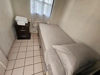 a small bed in a small room with a window at Buena Vista Home in Nueva San Salvador