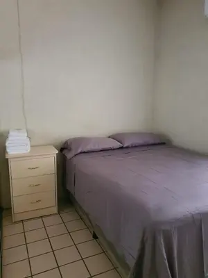 a small bedroom with a bed and a night stand at Buena Vista Home in Nueva San Salvador
