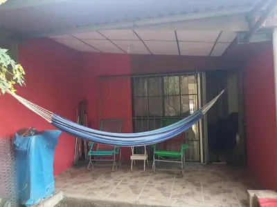 a hammock in the middle of a room with chairs at Buena Vista Home in Nueva San Salvador