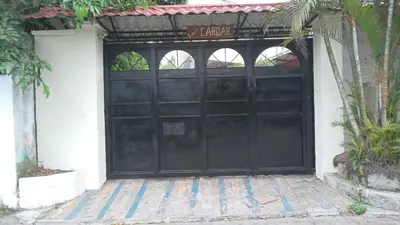 a black garage door with a sign on it at Country House in Los Planes VACATION RENTAL in Panchimalco
