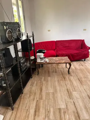 a red couch in a room with a wooden floor at Country House in Los Planes VACATION RENTAL in Panchimalco