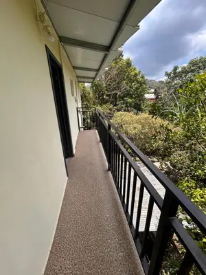 a balcony of a white building with a black railing at Country House in Los Planes VACATION RENTAL in Panchimalco
