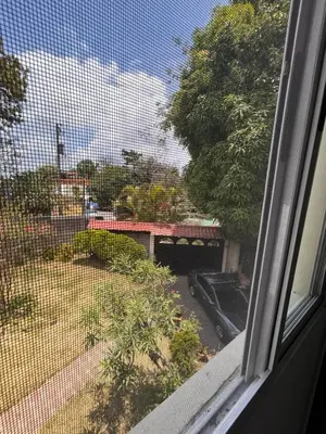 a window with a view of a yard with a car at Country House in Los Planes VACATION RENTAL in Panchimalco