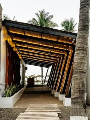a building with a wooden archway with palm trees at Barú in La Libertad