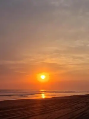 a sunset on a beach with the sun setting at Barú in La Libertad