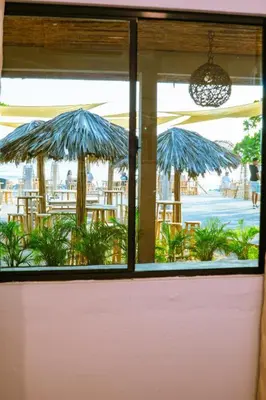 a window of a restaurant with tables and umbrellas at Barú in La Libertad