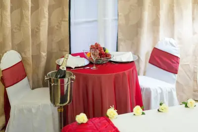 a red table with a bowl of fruit on it at Hotel Tropico Inn in San Miguel