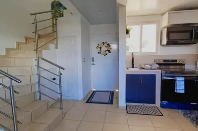 a kitchen with a staircase and a blue door at Modern Townhouse AC Wi-Fi full equipped Private in Santa Ana