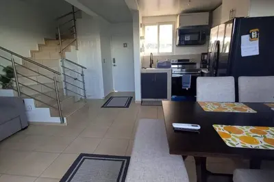 a living room with a kitchen and a dining table at Modern Townhouse AC Wi-Fi full equipped Private in Santa Ana