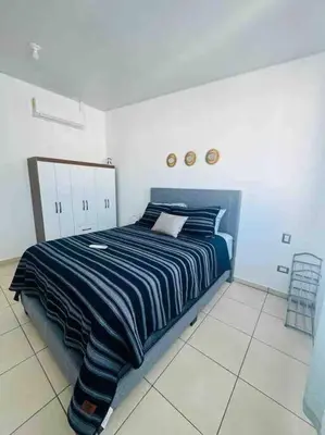 a bedroom with a bed with a blue and white striped blanket at Modern Townhouse AC Wi-Fi full equipped Private in Santa Ana
