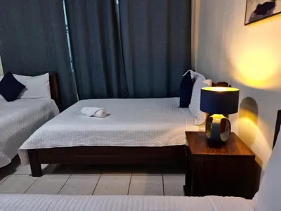 a bedroom with two beds and a lamp on a table at Hotel Sueños in San Salvador