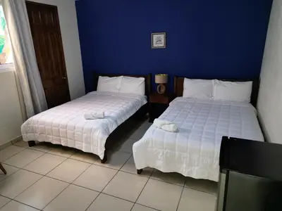 two beds sitting next to each other in a room at Hotel Sueños in San Salvador