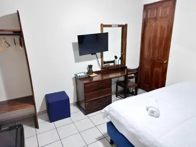 a bedroom with a desk with a mirror and a television at Hotel Sueños in San Salvador