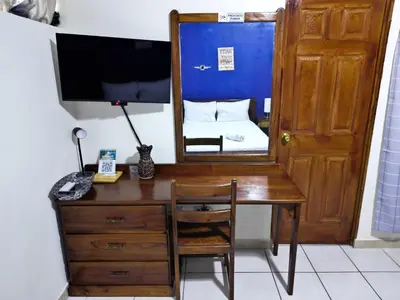 a desk with a mirror and a bed in a room at Hotel Sueños in San Salvador