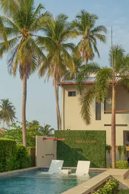 a villa with palm trees and a swimming pool at Mirasurf Hotel & Waves in El Sunzal