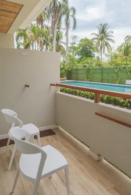 a balcony with white chairs and a swimming pool at Mirasurf Hotel & Waves in El Sunzal