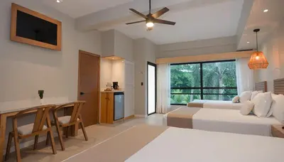 a bedroom with a bed and a table and a kitchen at Mirasurf Hotel & Waves in El Sunzal