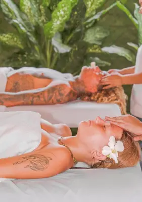 a woman laying on a bed with a flower on her face at Mirasurf Hotel & Waves in El Sunzal