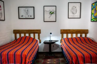 two beds sitting next to each other in a room at Hotel Anáhuac in Juayúa