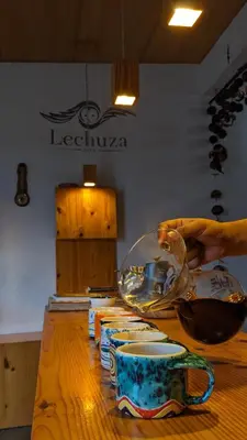 a person pouring food into a bowl on a wooden table at Hotel Anáhuac in Juayúa