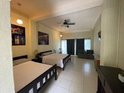 a bedroom with two beds and a living room at Coconut village in El Zapote