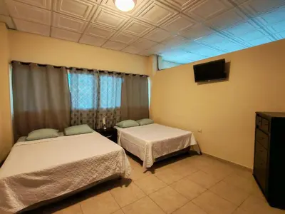 a room with two beds and a television in it at Coconut village in El Zapote