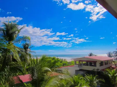 a house on the beach with palm trees and the ocean at Coconut village in El Zapote