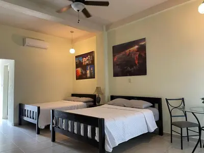 a bedroom with two beds and a ceiling fan at Coconut village in El Zapote