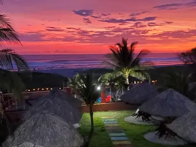 a resort with a view of the ocean at sunset at Coconut village in El Zapote