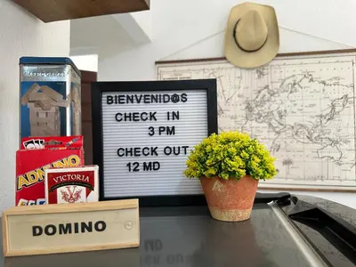 a sign on top of a table with a potted plant at Apartamento entero Rebeca house in Santa Ana