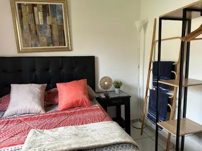 a bedroom with a bed with red and white pillows at Apartamento entero Rebeca house in Santa Ana