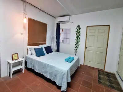 a bedroom with a bed with blue pillows on it at Coastal Paradise Estudio Cerca de Sunset Park y Playa in La Libertad