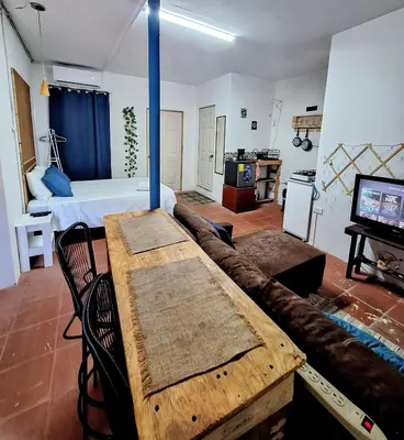 a living room with a couch and a bed and a television at Coastal Paradise Estudio Cerca de Sunset Park y Playa in La Libertad