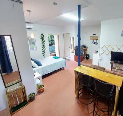 a living room with a bed and a mirror at Coastal Paradise Estudio Cerca de Sunset Park y Playa in La Libertad