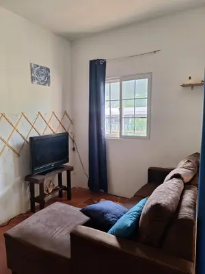 a living room with a couch and a television at Coastal Paradise Estudio Cerca de Sunset Park y Playa in La Libertad