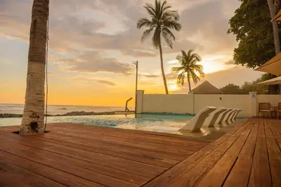 a swimming pool with a wooden deck and the ocean at The rooftop Beach & club in La Libertad